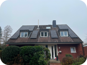 Rotes Backsteinhaus mit Solaranlagen auf dem Dach