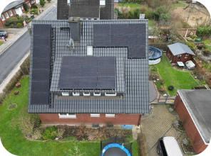 Seitliche Draufsicht auf ein Haus mit großem Garten, mit Solaranlagen auf dem Dach