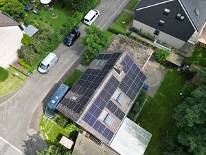 Draufsicht auf rotes Haus mit Solaranlagen auf dem Dach