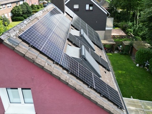 Rotes Haus mit Solaranlagen auf dem Dach