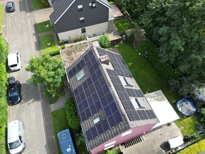 Draufsicht auf rotes Haus mit Solaranlagen auf dem Dach