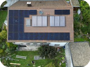 Draufsicht auf ein Haus mit Solaranlagen im Grünen