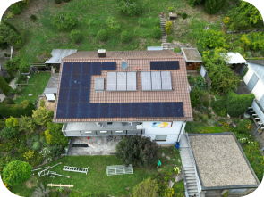 Draufsicht auf ein Haus mit Solaranlagen im Grünen