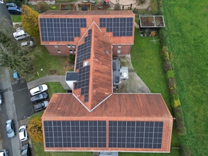 Draufsicht auf verwinkeltes Haus mit Solaranlagen auf dem Dach