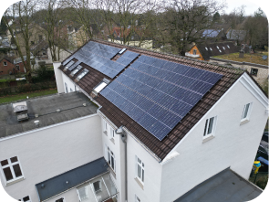 Solaranlagen auf dem Dach eines weißen, verwinkelten Hauses