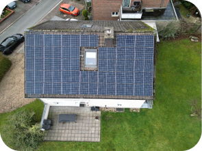 Haus bei dem die Hälfte des Daches mit Solaranlagen bedeckt ist