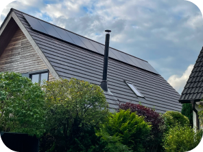 Haus umringt von Bäumen mit Solaranlagen auf dem Dach