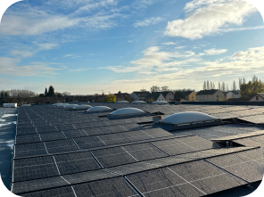 Mehrere Solaranlagen, die auf einem grauen Flachdach