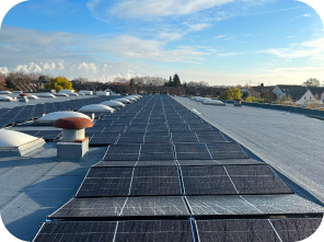 Mehrere Solaranlagen, die auf einem grauen Flachdach angebracht wurden