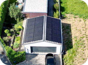 Weiße Garage vor der ein Auto parkt, mit einer Solaranlage auf dem Dach