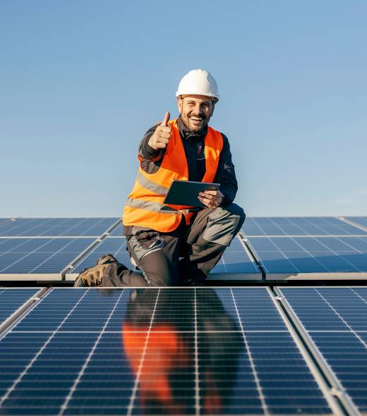 Arbeiter an einer Solaranlage der den Daumen hoch hält