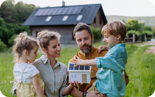 Eine Familie im Garten mit einem Haus im Hintergrund das eine Photovoltaikanlage auf dem Dach hat